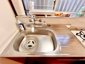 a silver sink in a caravan with a window at 千住4丁目2階 日本の和のお部屋スカイツリー9分秋葉原10分浅草12分 in Tokyo