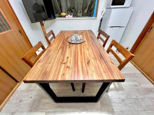 a wooden table with two chairs and a refrigerator at 千住4丁目2階 日本の和のお部屋スカイツリー9分秋葉原10分浅草12分 in Tokyo