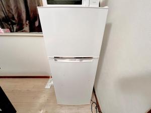 a white refrigerator sitting next to a white wall at 千住4丁目2階 日本の和のお部屋スカイツリー9分秋葉原10分浅草12分 in Tokyo