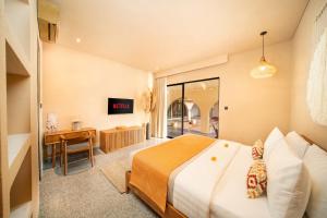 a hotel room with a bed and a desk at Cabana Kedungu Villa Tabanan by Ini Vie Hospitality in Tanah Lot +32 photos