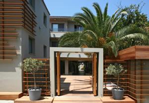 une entrée ouverte à un bâtiment avec deux plantes en pot dans l'établissement Bourtzi Hotel, à Skiathos Chora