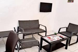 a living room with chairs and a table and a tv at Maison confortable à Le Moule avec piscine partagée in Le Moule