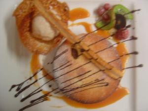 a piece of food on a plate with fruit at Logis Hôtel Les 3B in Nouilhan