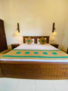 ein Schlafzimmer mit einem großen Bett mit zwei Lampen an der Wand in der Unterkunft Jade Banqueting and Leisure in Matara