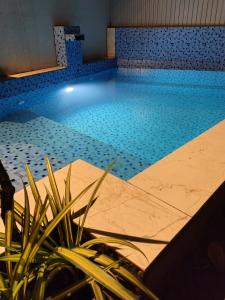 a swimming pool with a potted plant in the foreground at SpiceBuds TreeHouse - Idukki in Ramakkalmedu