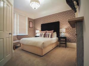 a bedroom with a large bed in a room with wallpaper at Stattons Boutique Hotel & Restaurant in Portsmouth