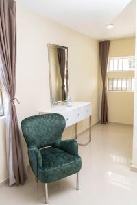 a green chair in a room with a mirror at La Isla Royal - Fisura Eterea in Miches