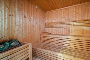 a wooden sauna with a wooden bench and rocks at Cozy 1 Br Apartment In Axis 2 Residence Dso in Dubai