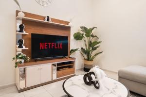 a living room with a television on a entertainment center at Cozy 1 Br Apartment In Axis 2 Residence Dso in Dubai