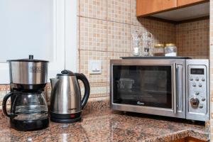 a microwave and a coffee maker on a kitchen counter at Cozy 1 Br Apartment In Axis 2 Residence Dso in Dubai