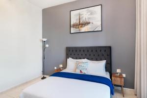 a bedroom with a bed and a picture on the wall at Cozy 1 Br Apartment In Axis 2 Residence Dso in Dubai