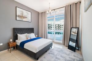 a bedroom with a bed and a large window at Cozy 1 Br Apartment In Axis 2 Residence Dso in Dubai