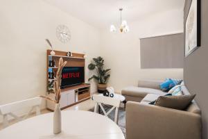 a living room with a couch and a tv at Cozy 1 Br Apartment In Axis 2 Residence Dso in Dubai +21 photos