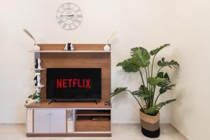 a television on a shelf with a netflix sign on it at Cozy 1 Br Apartment In Axis 2 Residence Dso in Dubai