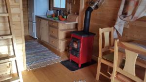 a wood stove in a room with a kitchen at Männiste Holiday Home in Hiievälja