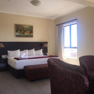 a hotel room with a bed and a window at Grange Gardens Hotel in Durban