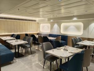 a dining room with tables and chairs and windows at Crystal Inn in Agra