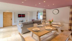 ein Wohnzimmer mit Tisch und Couch in der Unterkunft Beach Breeze Cottage - 3 Bed in Caister-on-Sea