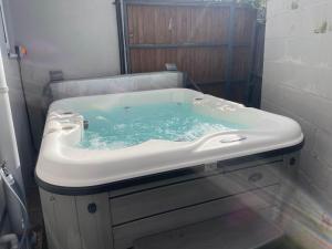 eine Badewanne mit blauem Wasser darin in der Unterkunft Beach Breeze Cottage - 3 Bed in Caister-on-Sea + 23 Fotos