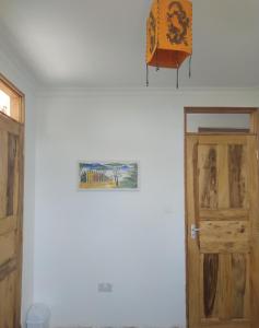 a room with a door and a picture on the wall at Room With Balcony In Family Farm House UK Host in Arusha