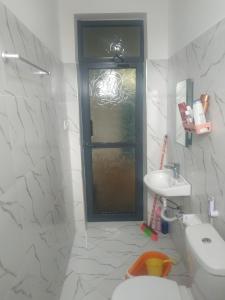 a bathroom with a toilet and a sink at Room With Balcony In Family Farm House UK Host in Arusha