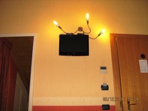 Un televisor en la pared con dos velas. en Hotel Mosca, en Monza