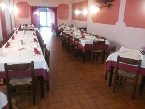una fila di tavoli in un ristorante con tovaglie bianche di Albergo Dell'angelo a Pontevico