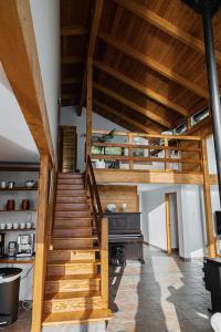 a wooden staircase in a room with a piano at First Light - Waterfront, Hot tub, Sauna, EV in Tofino