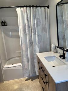 a bathroom with a shower and a sink and a tub at First Light - Waterfront, Hot tub, Sauna, EV in Tofino +36 photos