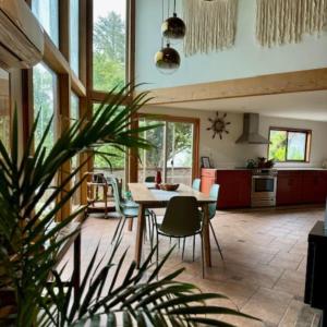 a kitchen and dining room with a table and chairs at First Light - Waterfront, Hot tub, Sauna, EV in Tofino