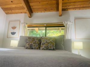 a bedroom with a bed with two lamps and a window at First Light - Waterfront, Hot tub, Sauna, EV in Tofino