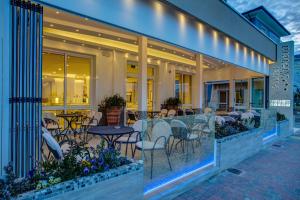 ein Restaurant mit Tischen und Stühlen auf einer Terrasse in der Unterkunft Hotel Riviera in Bellaria-Igea Marina