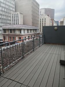 a balcony with a wooden deck in a city at Isibaya House in Johannesburg