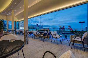 eine Terrasse mit Tischen und Stühlen und Meerblick in der Unterkunft Hotel Riviera in Bellaria-Igea Marina