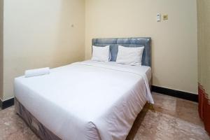 a large white bed in a small room at RedDoorz at Senaz Guesthouse Mataram in Mataram