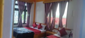 a bedroom with two beds and a window at Vanilla Homestay MOUNTAIN INN in Pedong