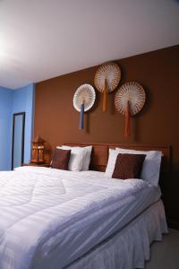 1 dormitorio con 1 cama grande con sábanas blancas y ventiladores en la pared en UPAR Hotels Silom, en Bangkok