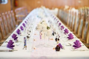 a long table with wine glasses and purple napkins at Retzerlandhof Familie Graf in Zellerndorf
