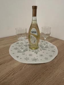 a bottle of wine sitting on a plate with two glasses at Cute and Cozy in Pale +5 photos