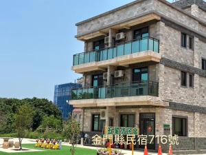 a building with a balcony on top of it at 五星佶民宿 in Jinning