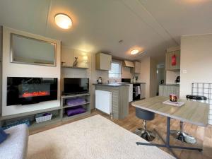 a living room with a table and a tv at Pass the Keys Cosy Welcoming 3BR in Beautiful Country Park in Beattock