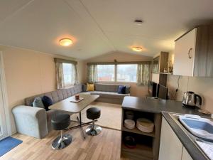 a kitchen and living room with a couch and a table at Pass the Keys Cosy Welcoming 3BR in Beautiful Country Park in Beattock +15 photos