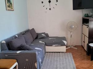 a living room with a couch and a clock on the wall at Two Bedroom Apartment with Terrace A1 in Splitska