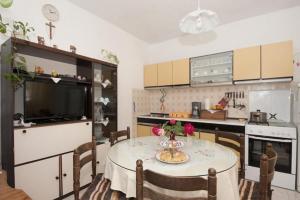 a kitchen with a table and a television and a table and chairs at Two Bedroom Apartment with Terrace A1 in Splitska