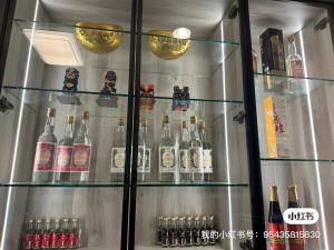 a refrigerator filled with lots of bottles of alcohol at 五星佶民宿 in Jinning