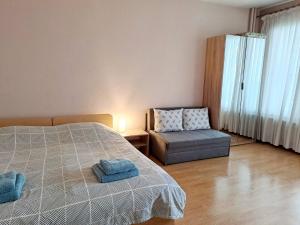 un dormitorio con una cama y una silla en LevskiG Studio 10 min from Sofia Airport and city centre, en Sofía