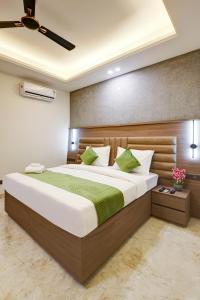 a bedroom with a large bed with green and white pillows at Limewood Stay Premium Studios - Near Sector 29 in Gurgaon
