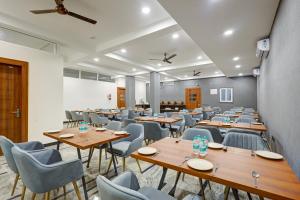 a conference room with wooden tables and chairs at Limewood Stay Premium Studios - Near Sector 29 in Gurgaon