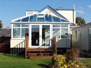 a conservatory with glass doors on a house at BlueHaven in Newquay
