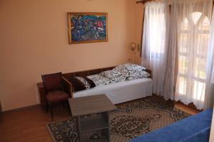 um quarto com uma cama, uma mesa e uma janela em Diófa Vendégház em Bükkszék